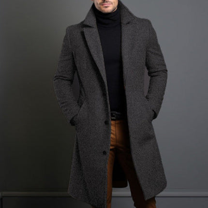 Man wearing a gray overcoat against a dark background