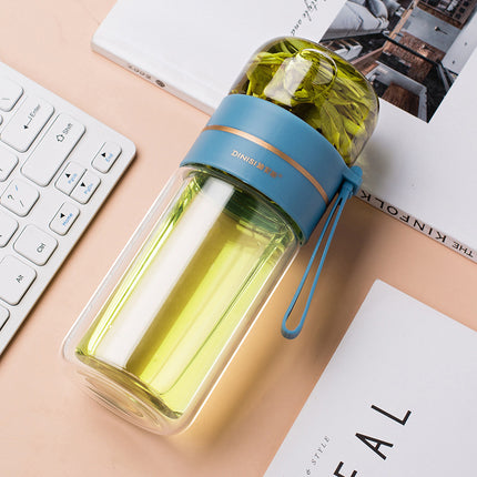 Clear glass bottle with green liquid and blue lid on a desk with keyboard and papers