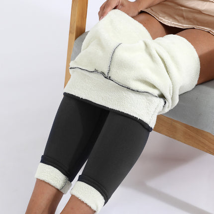Person wearing black leggings with white Sherpa trim sitting on a chair.