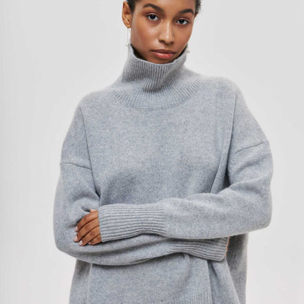 Person wearing a gray turtleneck sweater on a white background