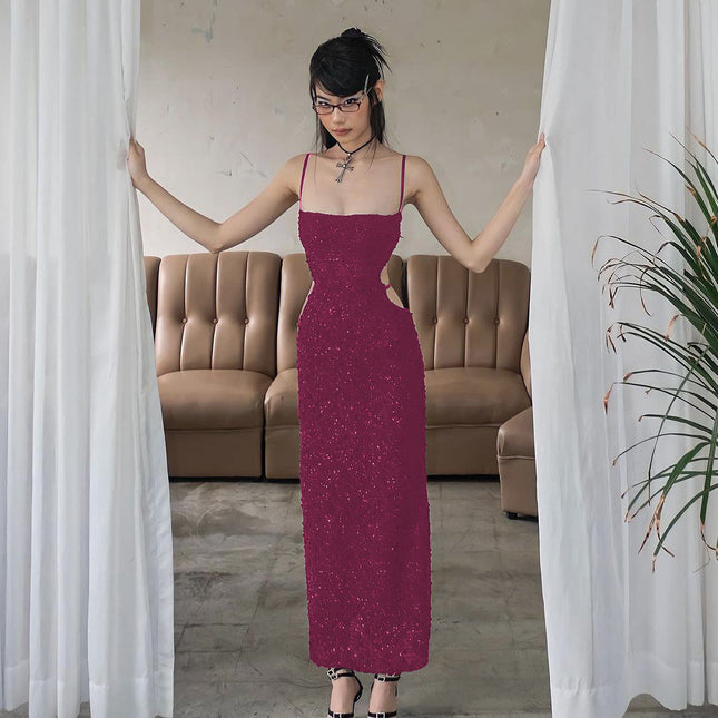 Woman in a long purple dress standing between white curtains in a room with a beige sofa.
