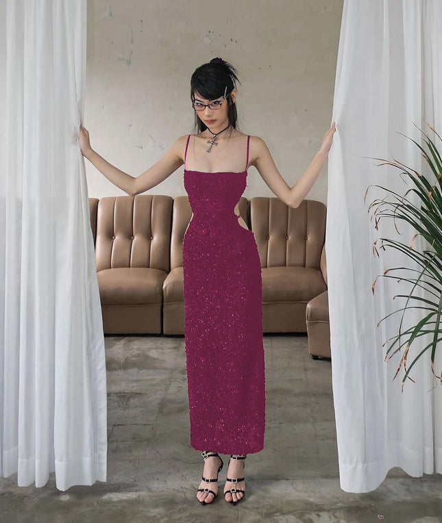 Woman in a long purple dress standing between white curtains in a room with a beige sofa.