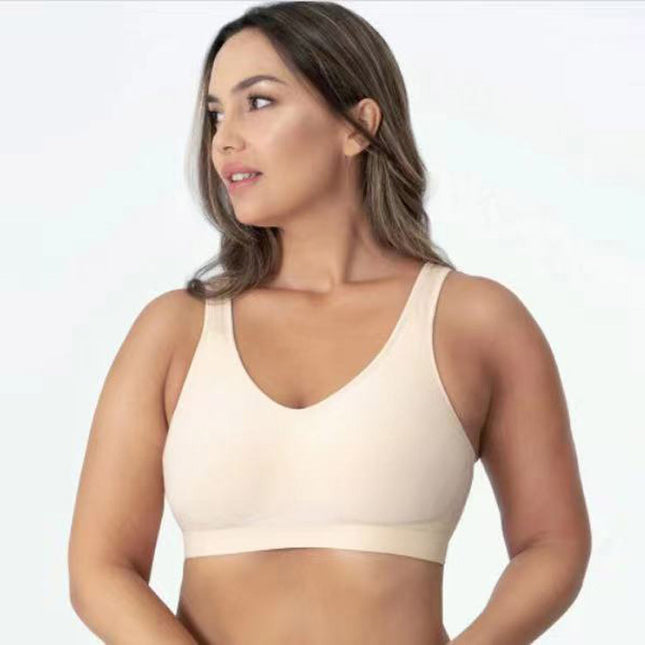 Woman wearing a beige bralette against a plain background