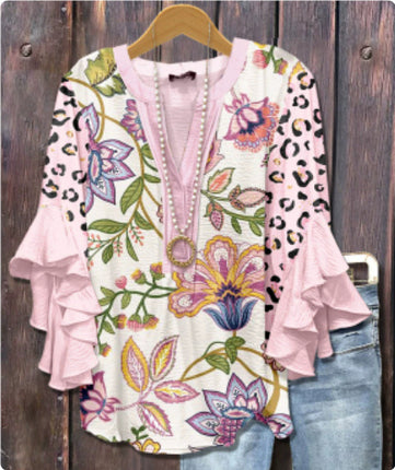 Floral and leopard print top with ruffled sleeves on a wooden background