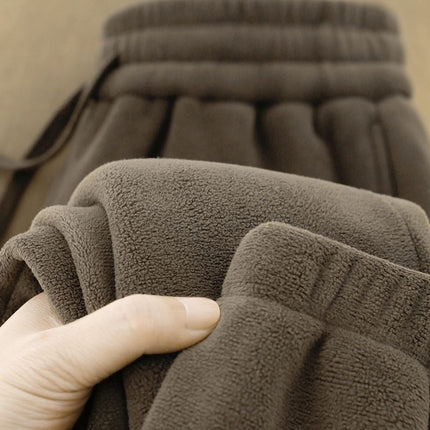 Brown fleece fabric held by a hand with a blurred background