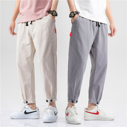 Two pairs of pants worn by people on a plain background
