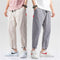 Two pairs of pants worn by people on a plain background