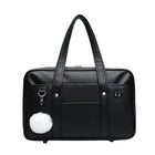 Black duffel bag with a white pom-pom charm on a white background