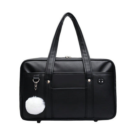 Black duffel bag with a white pom-pom charm on a white background