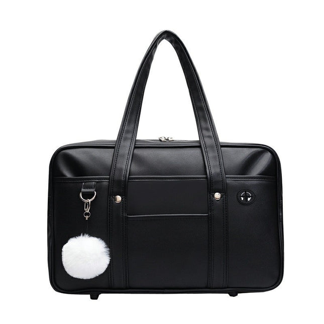 Black duffel bag with a white pom-pom charm on a white background