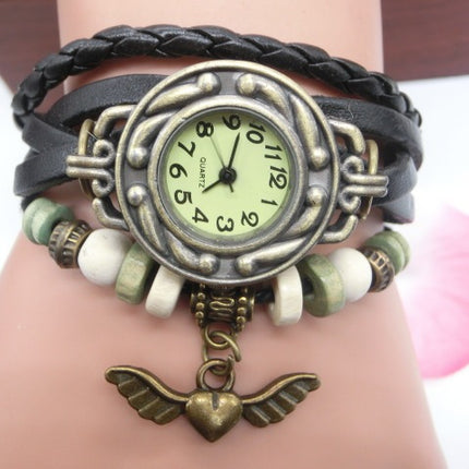 Bracelet watch with braided design and heart pendant on wrist