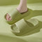 Green slippers worn by a person on a matching green background