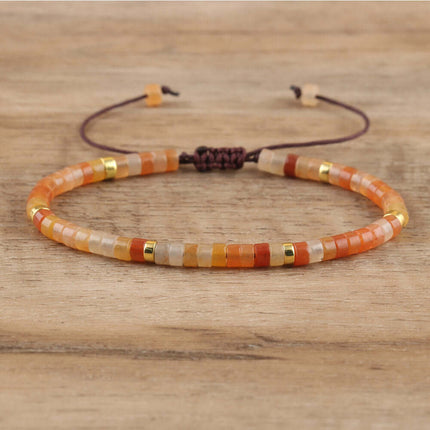 Adjustable women's bracelet made of orange and gold spacer beads, hand-woven on a brown cord.