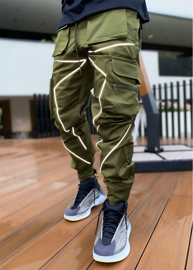 Person wearing green reflective pants on a wooden floor