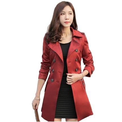 Woman wearing a wine red coat standing in front of a building.
