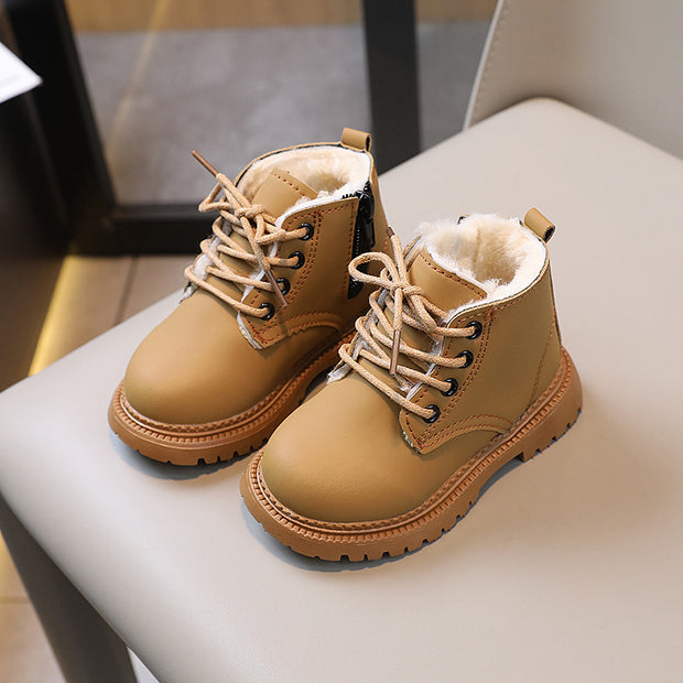Pair of tan children's boots with fur lining on a white surface.
