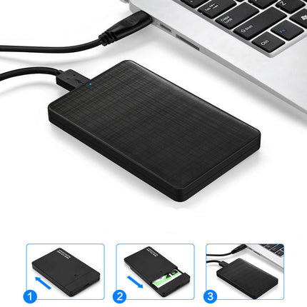 Black external hard drive with USB cable on a white surface, with a laptop in the background.