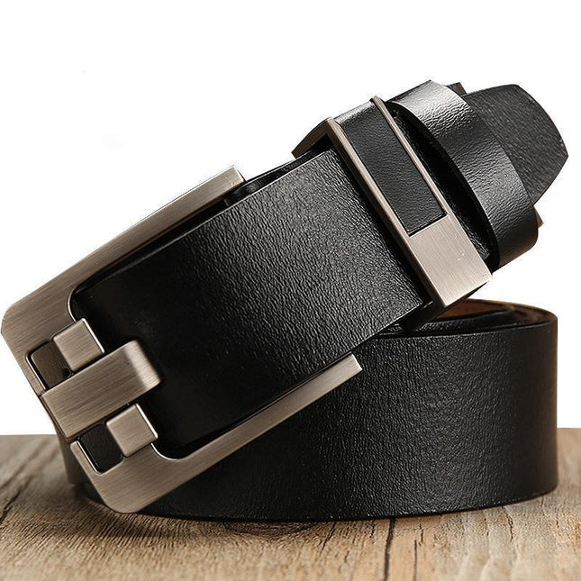 Black leather belt with a silver buckle on a wooden surface