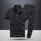 Black athletic outfit with short-sleeve top and pants on a gray background