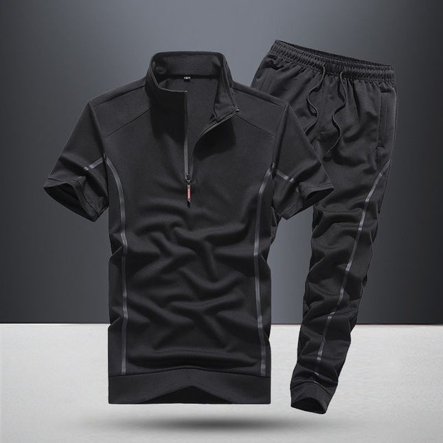 Black athletic outfit with short-sleeve top and pants on a gray background