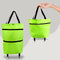 Green shopping bag with black straps and wheels on a gray background