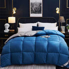 Blue comforter on a bed in a stylish bedroom with dark walls and decorative elements.