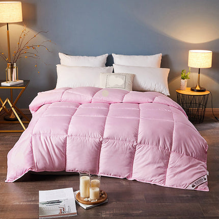 Pink comforter on a bed in a bedroom setting with side tables and lamps.