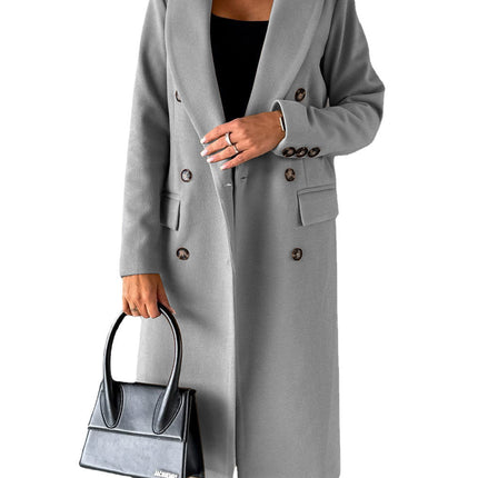Person wearing a gray coat holding a black handbag on a white background