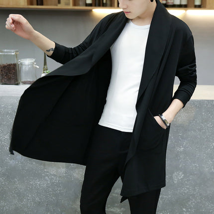 Person wearing a black cardigan over a white shirt in an indoor setting