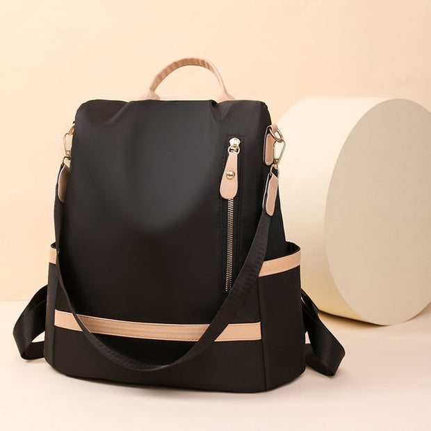 Black backpack with beige accents on a beige background