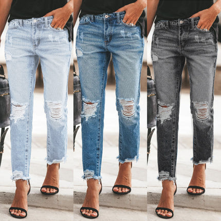 Three pairs of distressed jeans worn by different people on a blurred background.