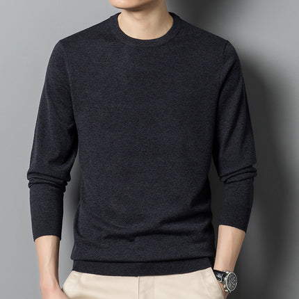 Person wearing a dark gray sweater against a gray background