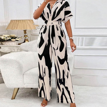Woman wearing a black and white patterned jumpsuit in a living room setting.