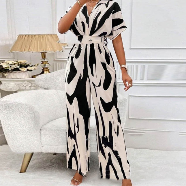 Woman wearing a black and white patterned jumpsuit in a living room setting.