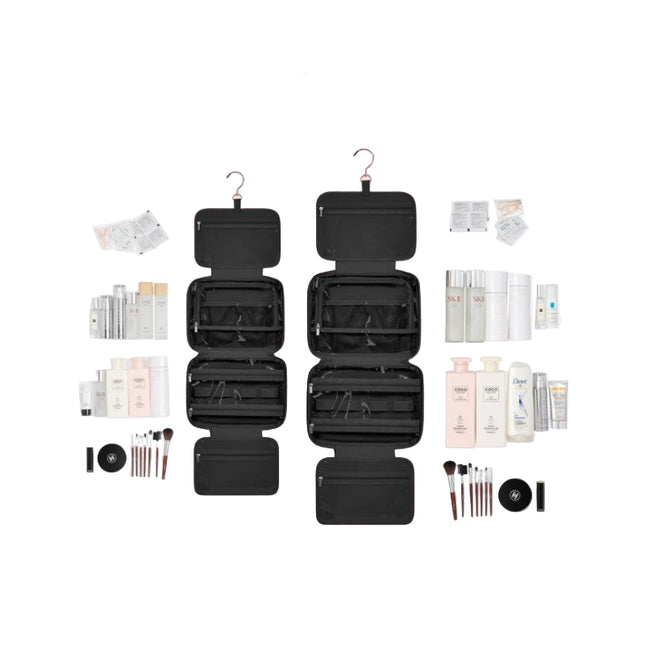 Black travel organizer with hanging and flat compartments, surrounded by cosmetic products on a white background.