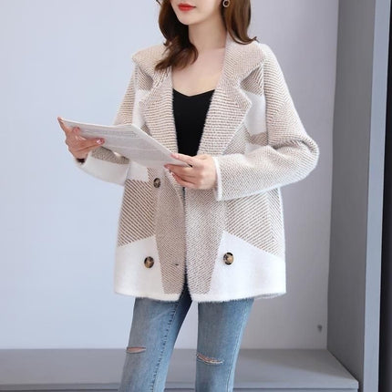 Woman wearing a beige and white coat with button details, holding a tablet.