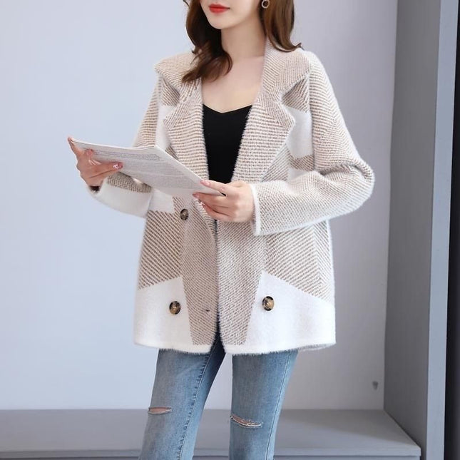 Woman wearing a beige and white coat with button details, holding a tablet.