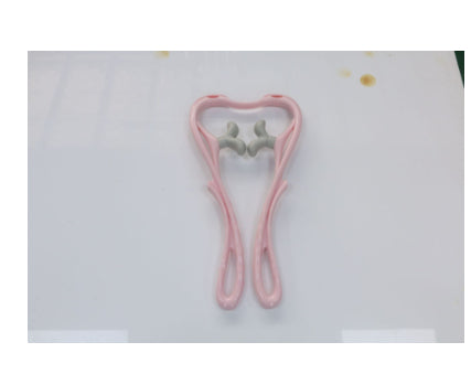 Pink hair clip shaped like a tooth on a white background