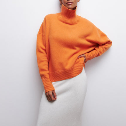 Person wearing an orange sweater against a white background
