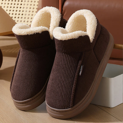 Brown slip-on shoes with white fur lining on a wooden floor.