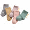 Set of five baby socks in different colors on a white background