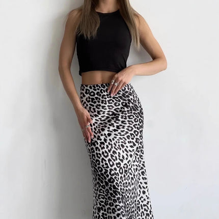 Person wearing a black crop top and leopard print skirt against a white background