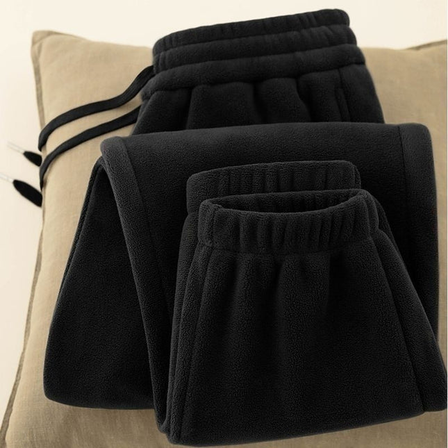 Folded black pants on a beige cushion