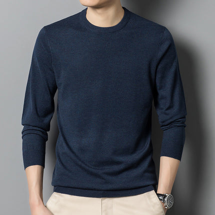 Person wearing a navy blue sweater against a gray background