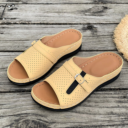 Pair of beige sandals on a wooden surface