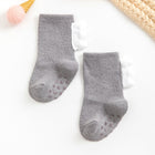 Pair of gray baby socks with non-slip dots on a white background