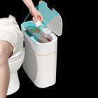 Hand using a cleaning tool on a white bidet in a bathroom setting.