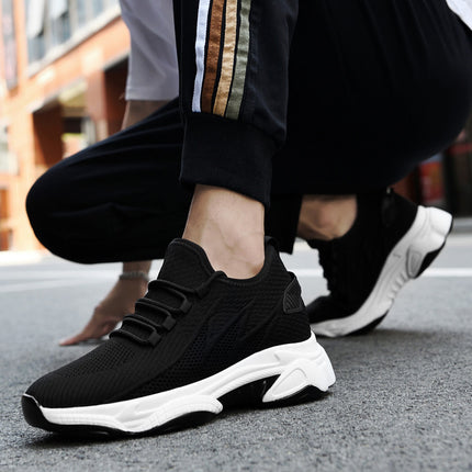 Black and white sneakers worn by a person on a street.