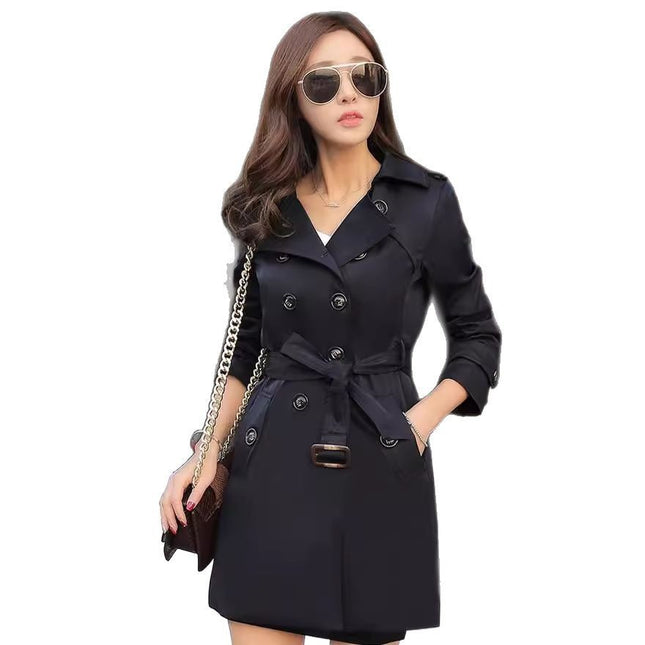 Woman wearing a black trench coat on a white background