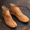 Pair of tan leather shoes on a dark wooden surface